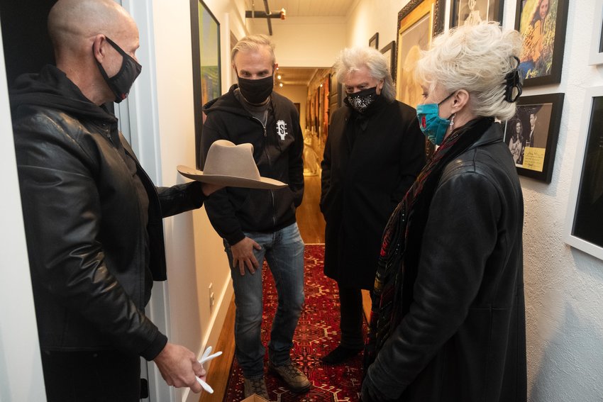 Doug Hudson, left, gathers with John Peets, Marty Stuart and his wife Connie Smith in Hudson’s Busy Bee Suites apartment as they look at a hat that belonged to Hank Williams Sr., all part of Stuart’s Congress of Country Music that is being developed here.